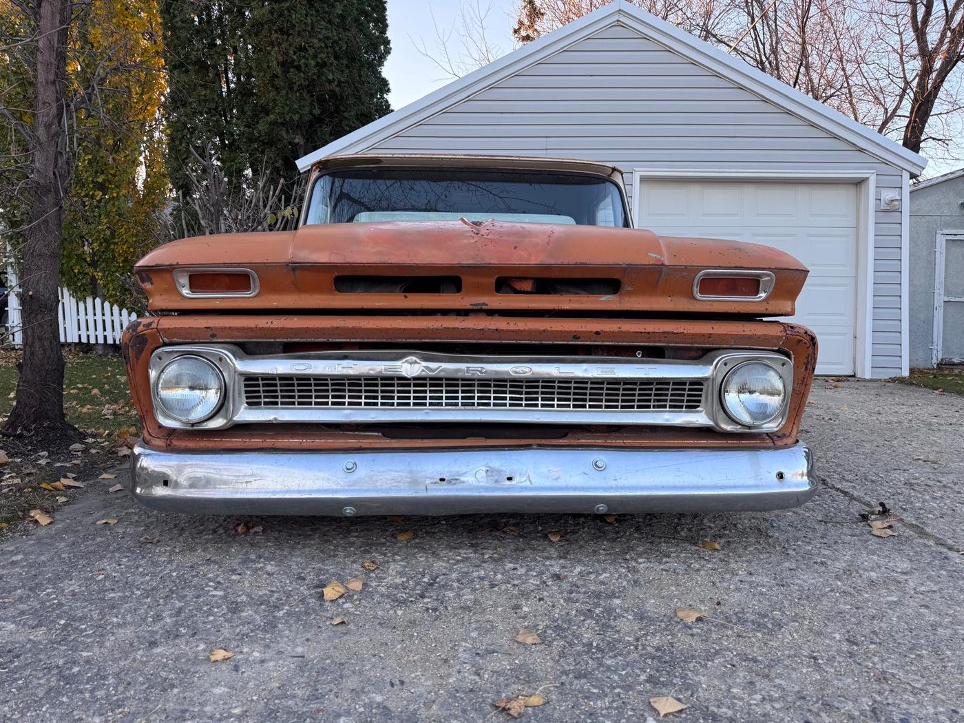 Head-on view of the orange pickup's chrome Chevrolet grille and bumper